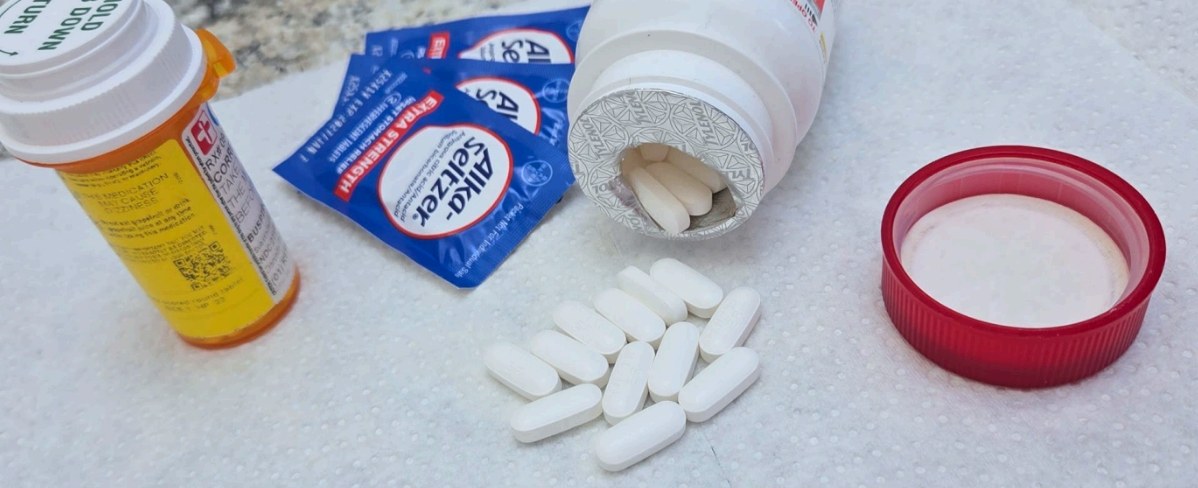 Various medication bottles and loose pills on a white surface